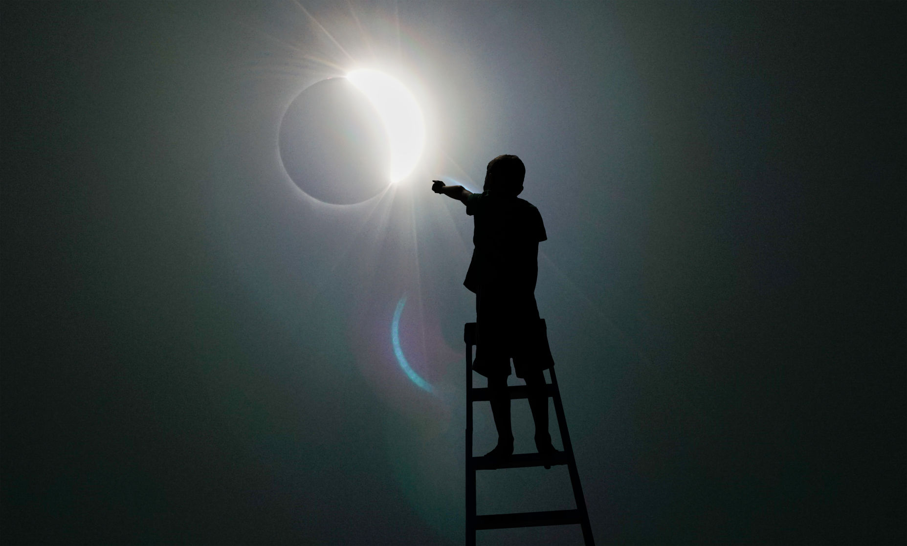 Boy on ladder watches the eclipse